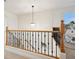 Upstairs hallway with wooden railing, chandelier and natural light at 10948 Carberry Hill St, Las Vegas, NV 89141