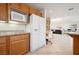 Open kitchen area featuring oak cabinets, a white refrigerator, and ample counter space at 10948 Carberry Hill St, Las Vegas, NV 89141