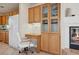 Bright kitchen featuring oak cabinets, a built-in desk, and a cozy fireplace at 10948 Carberry Hill St, Las Vegas, NV 89141