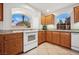 Kitchen featuring oak cabinets, granite countertops, and arched windows at 10948 Carberry Hill St, Las Vegas, NV 89141