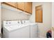 Functional laundry room with washer, dryer, and built-in storage cabinets at 10948 Carberry Hill St, Las Vegas, NV 89141