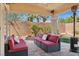 Covered patio with ample seating and view of landscaped backyard at 10948 Carberry Hill St, Las Vegas, NV 89141