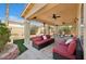 Covered patio with seating, ceiling fans, and a well-manicured backyard at 10948 Carberry Hill St, Las Vegas, NV 89141
