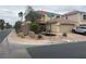 A quiet street view showcases a landscaped corner property with a two-story home and tile roof at 10948 Carberry Hill St, Las Vegas, NV 89141