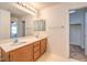 Bathroom featuring a double sink vanity, large mirror and linen closet at 11177 Deluna St, Las Vegas, NV 89141