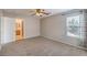 Cozy carpeted bedroom with a ceiling fan, a window with curtains, and a view into the adjacent bathroom at 11177 Deluna St, Las Vegas, NV 89141