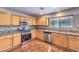 Modern kitchen boasts stainless steel appliances, granite countertops, wood cabinets, and ample counter space at 11177 Deluna St, Las Vegas, NV 89141