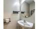Stylish powder room featuring a pedestal sink, oval mirror, and decorative shelves for storage at 11177 Deluna St, Las Vegas, NV 89141