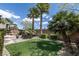 Landscaped backyard with palm trees and artificial turf, creating a private oasis at 11177 Twilight Times Ct, Las Vegas, NV 89135