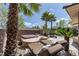 Backyard oasis with a hot tub and lounge chairs, surrounded by lush landscaping at 11177 Twilight Times Ct, Las Vegas, NV 89135