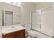 Bathroom featuring a wood vanity, large mirror, toilet and shower with sliding glass doors at 11177 Twilight Times Ct, Las Vegas, NV 89135