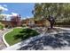 Attractive home exterior with a lush, green front lawn, mature tree, and stone accents enhancing curb appeal at 11177 Twilight Times Ct, Las Vegas, NV 89135