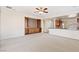 Open-concept living area with cozy carpet, ceiling fan, built-in shelving and adjacent kitchen for easy entertaining at 11177 Twilight Times Ct, Las Vegas, NV 89135