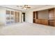 Spacious living room featuring plush carpeting, a ceiling fan, and built-in shelving, perfect for relaxation and storage at 11177 Twilight Times Ct, Las Vegas, NV 89135