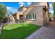 Manicured backyard offers a green lawn, a covered patio and gravel beds at 11340 Espadrille Ct, Las Vegas, NV 89138