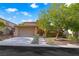 Charming two-story home features a well-maintained front yard, mature tree, and attached two-car garage at 11340 Espadrille Ct, Las Vegas, NV 89138
