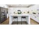 Stylish kitchen with white cabinets, stainless steel appliances, quartz countertops, and island with seating at 11340 Espadrille Ct, Las Vegas, NV 89138