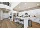 Open kitchen features white cabinets, stainless steel appliances, center island with bar seating, and modern fixtures at 11340 Espadrille Ct, Las Vegas, NV 89138