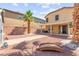 The backyard has a covered patio, palm tree, gravel ground, brick wall, and a small bridge at 11755 Garland Grove Ln, Las Vegas, NV 89183