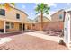 The backyard has a covered patio, palm tree, gravel ground, and a brick wall at 11755 Garland Grove Ln, Las Vegas, NV 89183