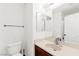 Bathroom with a white toilet and sink, updated vanity and a large mirror at 11755 Garland Grove Ln, Las Vegas, NV 89183