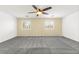 Spacious bedroom with ceiling fan, neutral walls, plush carpeting and ample natural light from two windows at 11755 Garland Grove Ln, Las Vegas, NV 89183