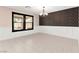 Bright, open dining room with neutral tiled floors and natural light from a large window at 11755 Garland Grove Ln, Las Vegas, NV 89183