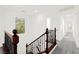 Upstairs hallway featuring carpeted floors, wood and metal railings, and bright natural light from windows at 11755 Garland Grove Ln, Las Vegas, NV 89183
