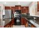 Modern kitchen with stainless steel appliances, granite countertops, and dark wood cabinetry at 11755 Garland Grove Ln, Las Vegas, NV 89183