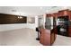 Modern kitchen and living room combo featuring stainless steel appliances and barstool seating at the island at 11755 Garland Grove Ln, Las Vegas, NV 89183