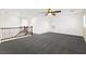 Expansive living room with large windows, wood railing, and plush carpeting at 11755 Garland Grove Ln, Las Vegas, NV 89183