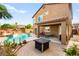 Spacious backyard with pool, grotto, patio seating, and desert landscaping with a fire pit at 1200 Dream Bridge Dr, Las Vegas, NV 89144