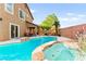 Inviting backyard with pool, hot tub, rock features, and outdoor dining area at 1200 Dream Bridge Dr, Las Vegas, NV 89144