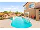 Large backyard featuring a pool, grotto with waterfall, and a patio with dining area at 1200 Dream Bridge Dr, Las Vegas, NV 89144