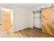 Bright bedroom featuring a decorative barn door and wood-look flooring at 1200 Dream Bridge Dr, Las Vegas, NV 89144