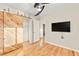 Bedroom with a ceiling fan, wood floors, barn door, and a wall-mounted television at 1200 Dream Bridge Dr, Las Vegas, NV 89144
