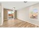 Bright dining room with chandelier, wood-look flooring, and sliding glass door to the backyard at 1200 Dream Bridge Dr, Las Vegas, NV 89144