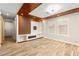 Contemporary living area with wood-look floors, custom media center, and ample natural light creating a welcoming space at 1200 Dream Bridge Dr, Las Vegas, NV 89144