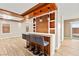 Stylish bar with seating, wood accents, and pendant lighting, seamlessly connecting to the living spaces and backyard at 1200 Dream Bridge Dr, Las Vegas, NV 89144