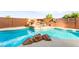 Backyard pool featuring a grotto with lush greenery, a rock waterfall, and serene landscaping at 1200 Dream Bridge Dr, Las Vegas, NV 89144