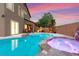 Backyard oasis featuring a sparkling pool, spa with rock accents, and covered patio for outdoor enjoyment at 1200 Dream Bridge Dr, Las Vegas, NV 89144