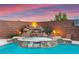 Inviting pool with a spa featuring a rock waterfall and manicured landscaping, perfect for relaxation at 1200 Dream Bridge Dr, Las Vegas, NV 89144