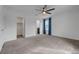 Large bedroom features plush carpeting, a ceiling fan, natural light, and access to the walk-in closet and bathroom at 1200 Paradise Basin Ct, Henderson, NV 89002