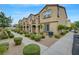 Exterior view of lovely townhomes featuring tidy landscaping and ample parking perfect for community living at 1200 Paradise Basin Ct, Henderson, NV 89002