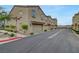 View of attached garages of neutral-toned townhomes with tile roofs and shutters along a wide neighborhood street at 1200 Paradise Basin Ct, Henderson, NV 89002