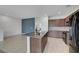 Open kitchen with granite island, stainless appliances, tile floors, and a dining area at 1200 Paradise Basin Ct, Henderson, NV 89002