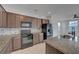 Modern kitchen showcases tile backsplash, and dark cabinets with granite countertops for a sleek design at 1200 Paradise Basin Ct, Henderson, NV 89002