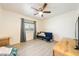 Comfortable bedroom with light wood flooring, large window with gray curtains, and ceiling fan at 1251 Cavalry St, Pahrump, NV 89048
