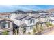 View of rooftops of homes in gated community with desert landscaping, solar panels on roof at 1323 Cerulean Ave, Henderson, NV 89002