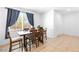 Bright dining area with tile flooring, window with blue curtains and a wooden table with six chairs at 1323 Cerulean Ave, Henderson, NV 89002